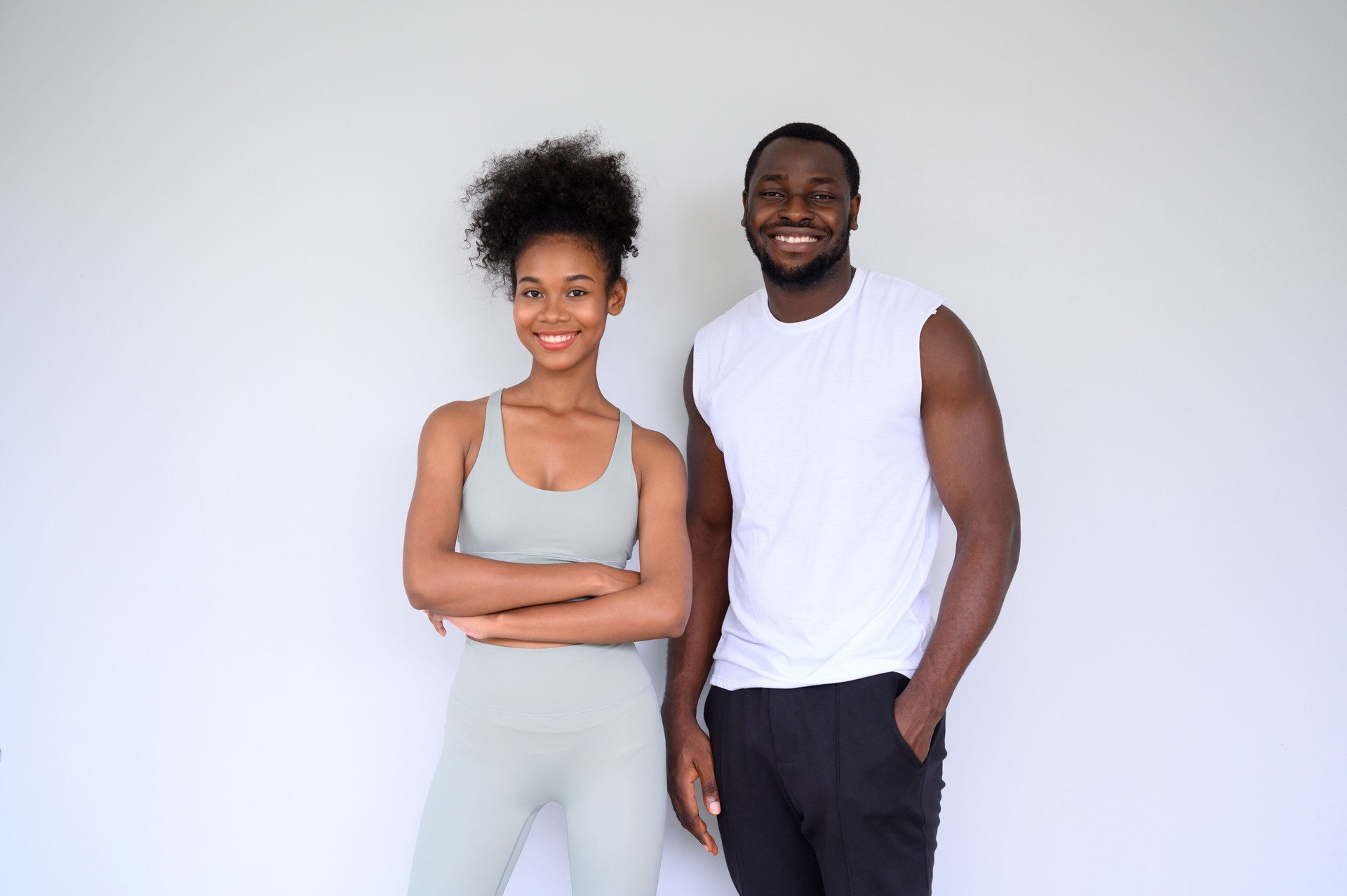 portrait of young couple of African Americans posing in fitness clothes over white background. Healthy and Fitness concept.